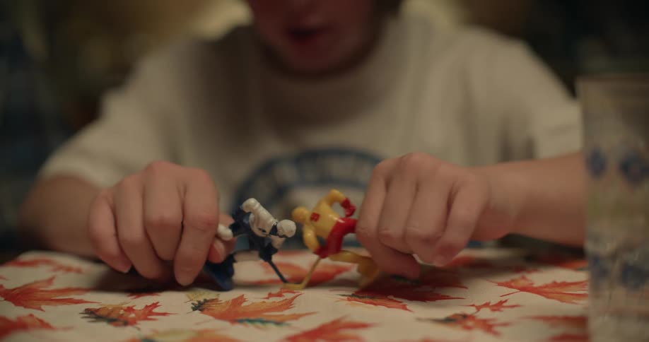 Teenager plays with hockey figures at table