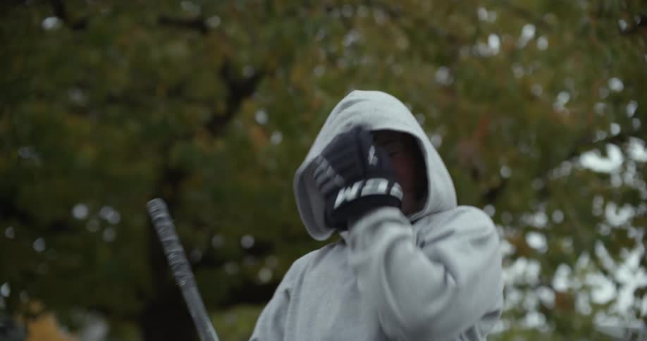 Teenage girl practices hockey outdoors near tree