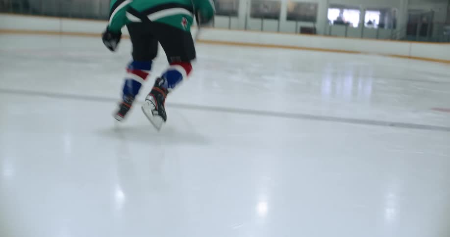 Lonely young hockey players starts a run over the rink wearing full team gear