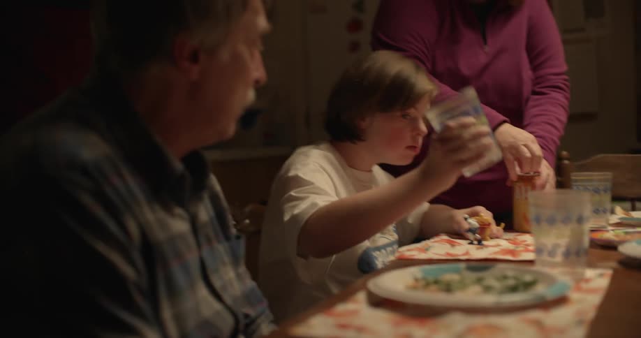 Grandmother serving the table for dinner for her husband and granddaughter at home