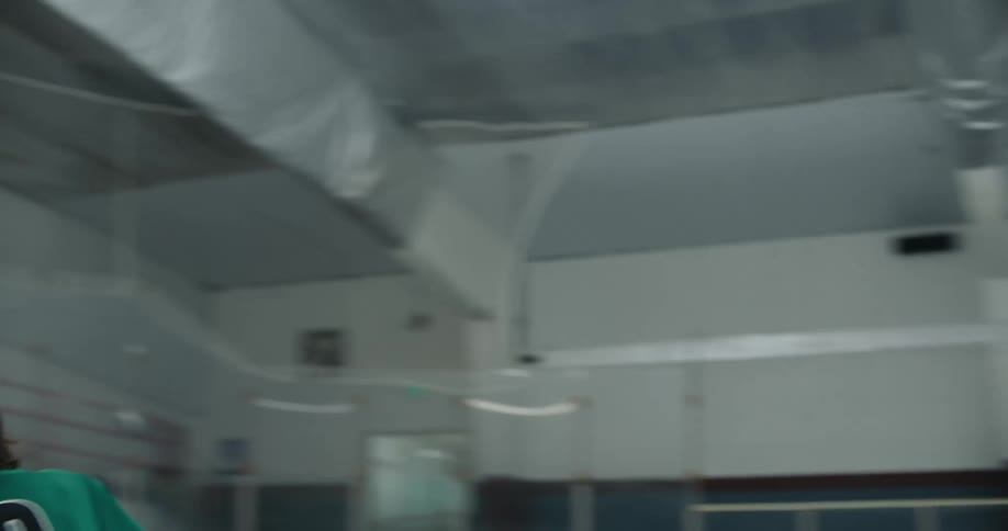 A hockey player skates across the ice and hits a puck into the goal
