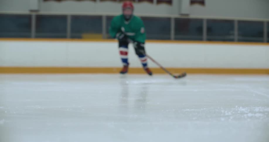 A hockey player drives the puck