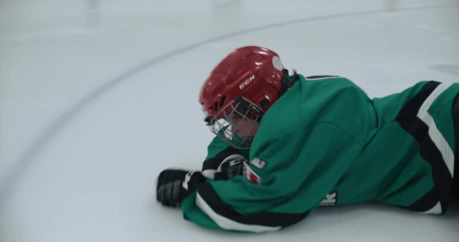 Hockey player skates across rink and falls