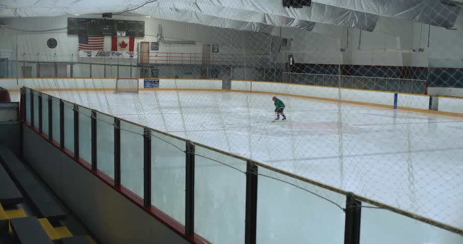 A person drives the puck into the net on the ice rink