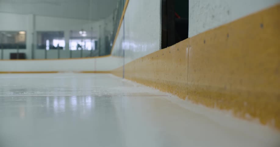Young girl enters a ice hokey skate rink wearing full team gear