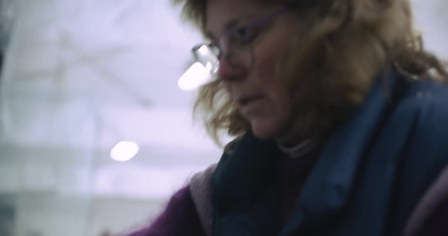 A woman helps by removing someones ice skates