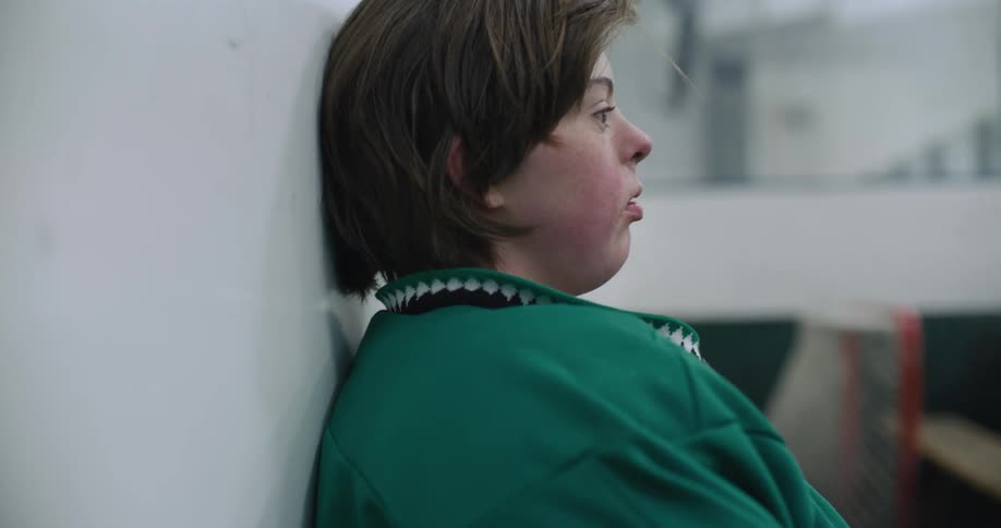 Woman leans against wall breathing deeply