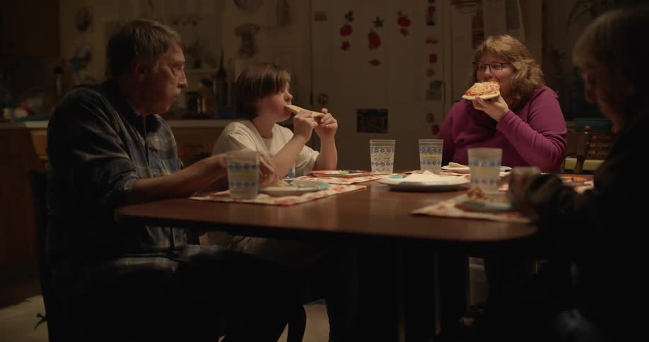 A family sits at a dinner table eating food