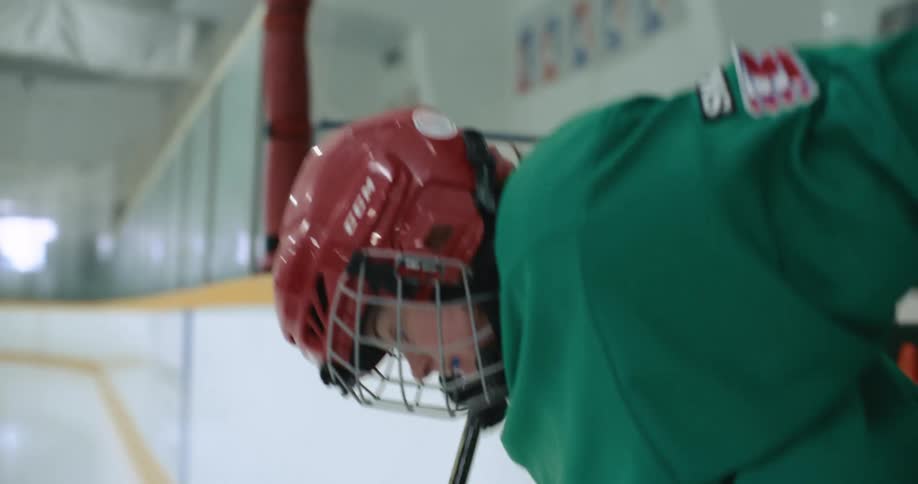 Young girl wearing ice hockey sports team equipment carefully enters an ice rink