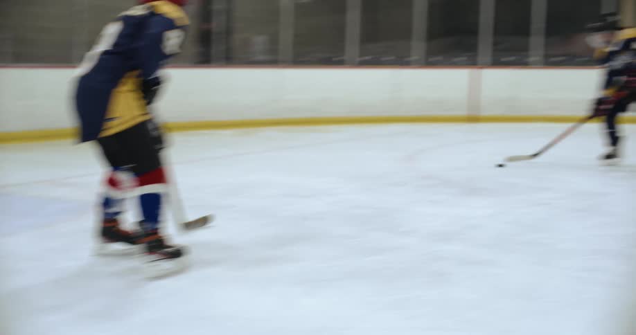 Three hockey players practice in ice rink
