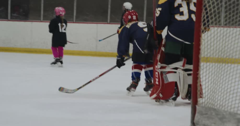 Hockey players skate around ice rink
