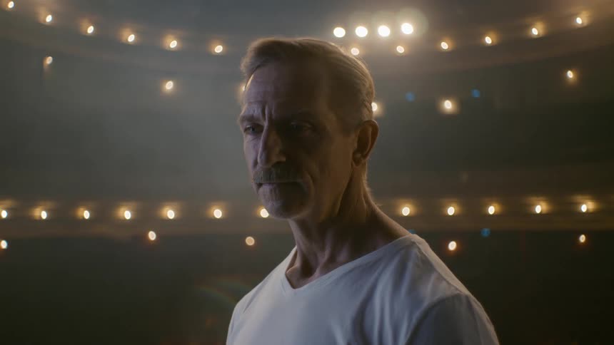 Man stands looking around lit empty theater