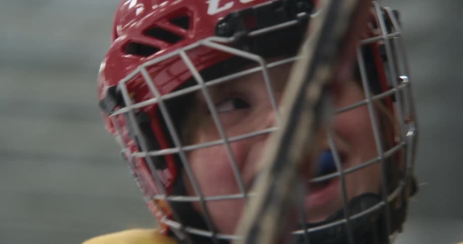 Kids wearing ice hockey gear celebrating in the ice rink