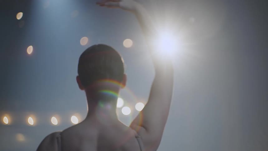 A woman is dancing ballet on stage