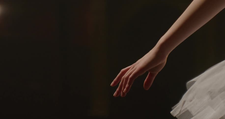 A person reaches their hand out under the lights