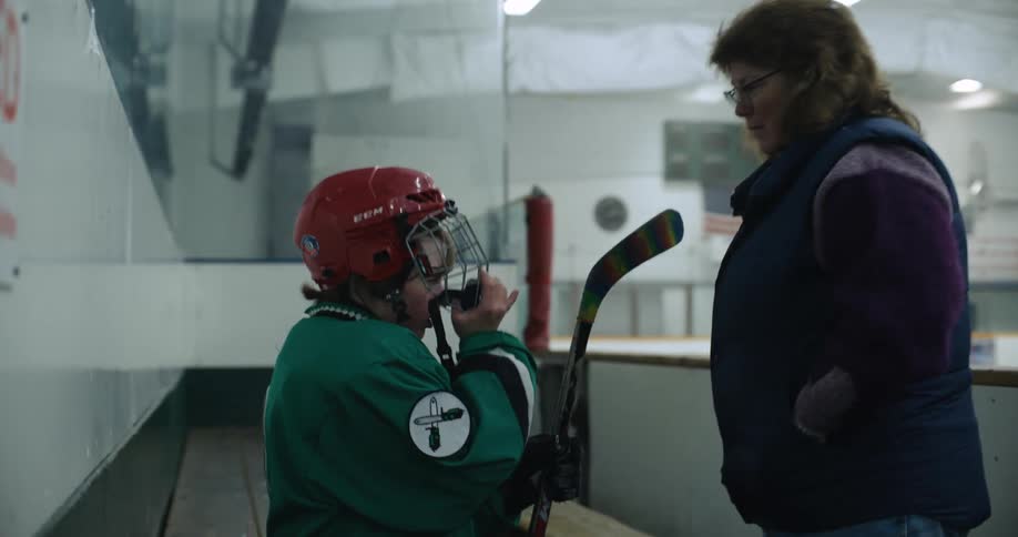 Woman helps teenage hockey player remove helmet