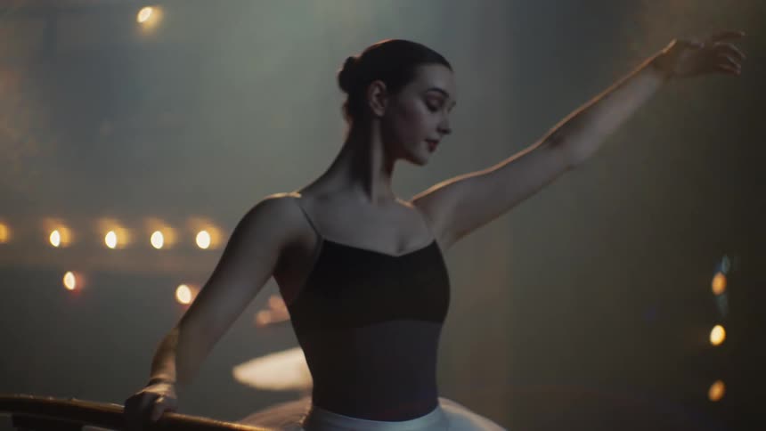 A pair of ballerinas practice ballet on a stage in a theater