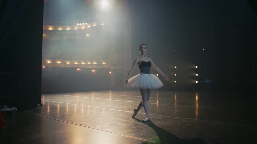 A teenage girl dances ballet on a stage