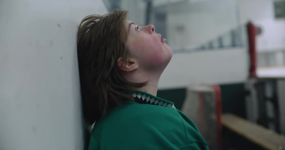 A hockey player leans against the wall