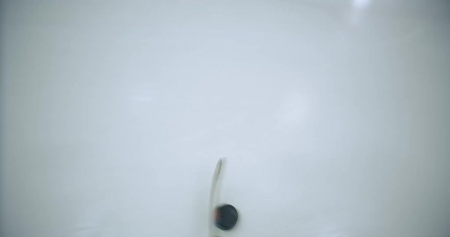 A person hitting a puck with a hockey stick