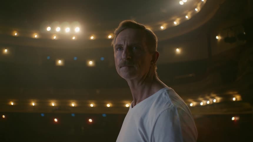 A man walks across a stage in a theater