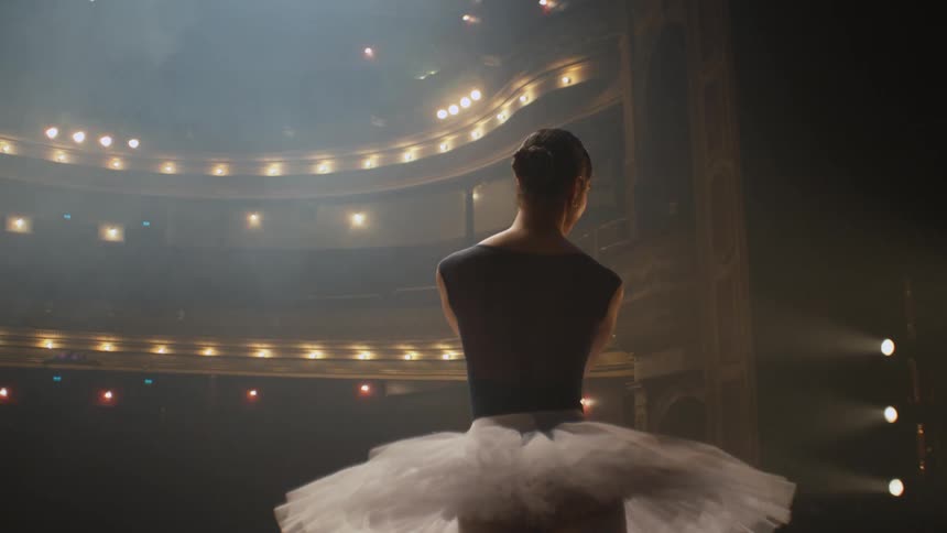A ballerina dances on a stage in theater