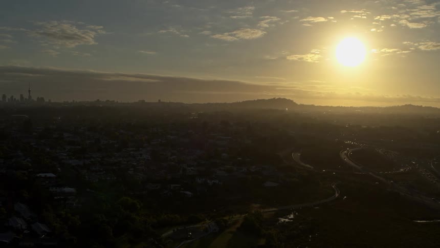Traffic flows along freeway as fog obscures city skyline