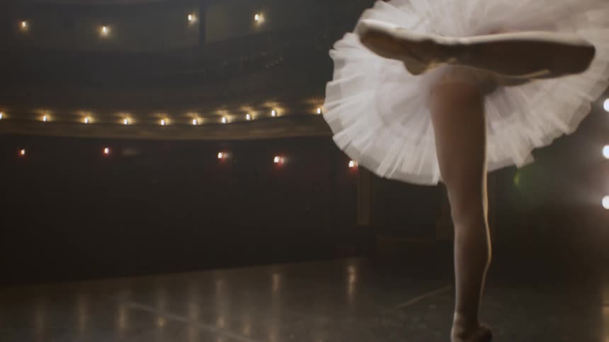 A woman dances ballet on a stage