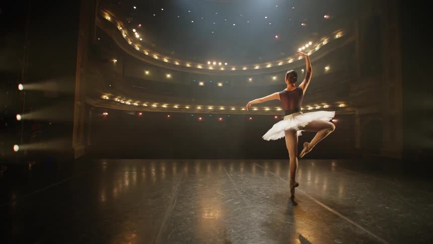 Ballerina dancing on stage in a vacant theater