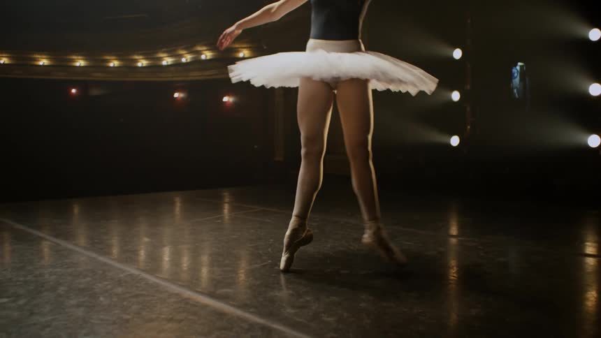 Ballerina dances across stage in empty theater