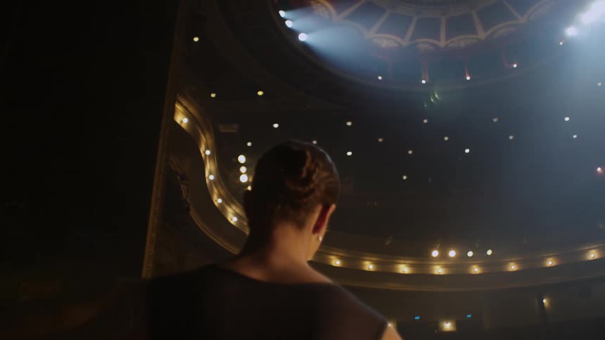 Ballerina dances across stage in empty theater