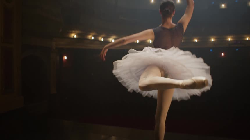 A ballerina dancing en pointe in a tutu on a stage