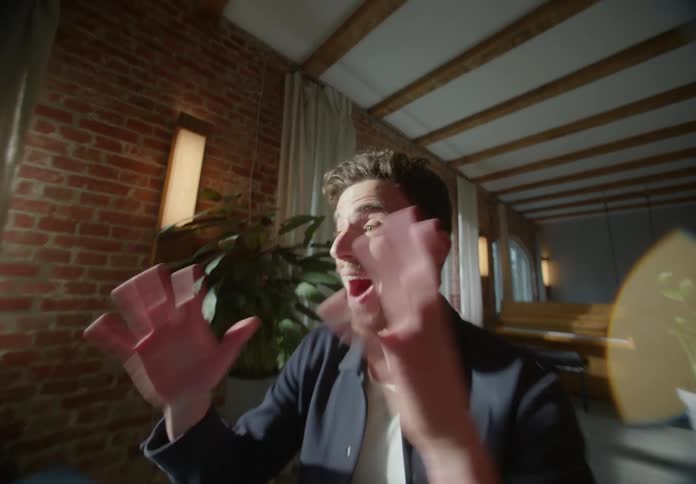 A man raises his hands talking to his computer