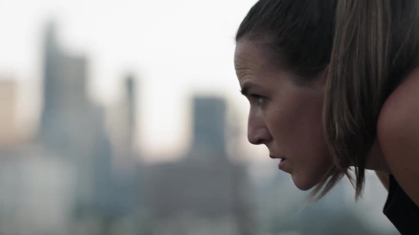 A woman in a ponytail wipes her face