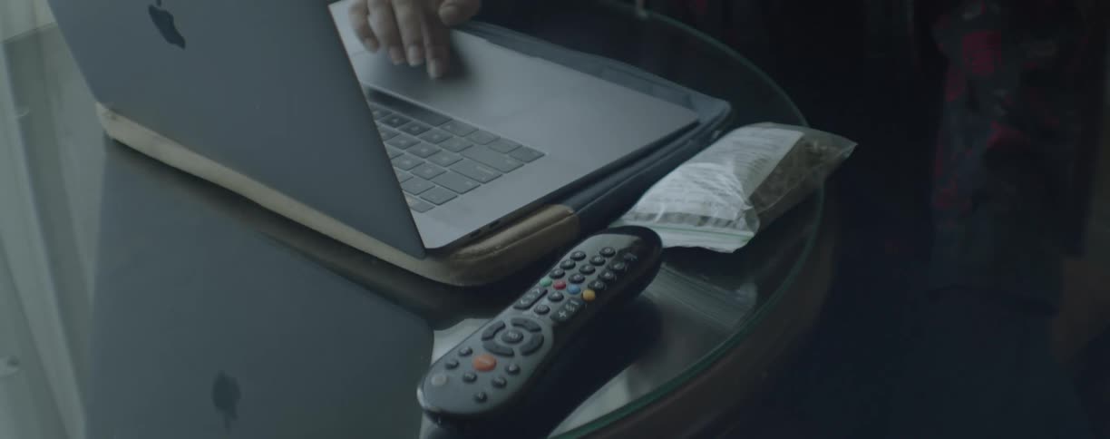 A woman sits at a table and uses a laptop