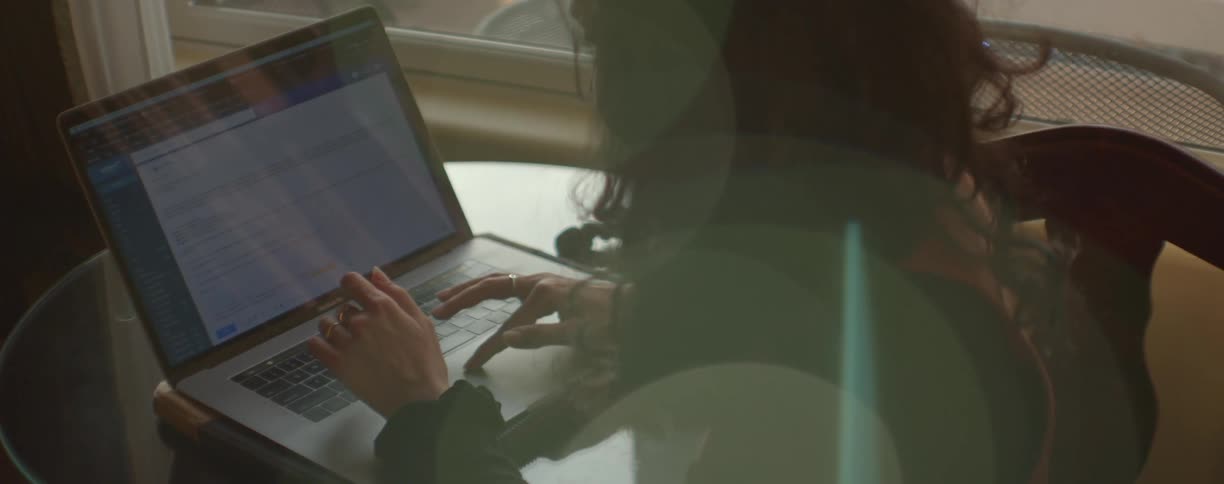 A woman types a document on her laptop