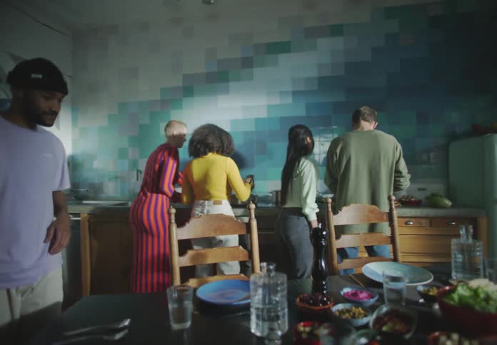 A group of friends cook a meal together at home