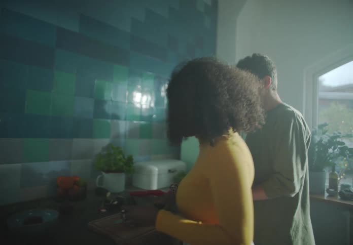 A man and woman prepare food together in a kitchen