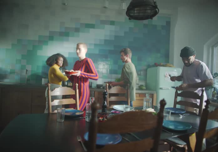 Friends work together to cook and put food on the table