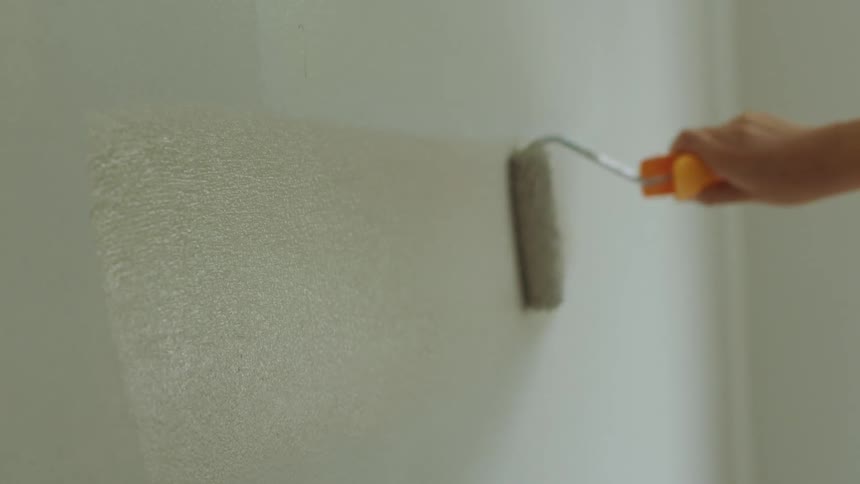 Someone is painting a wall with a paint roller