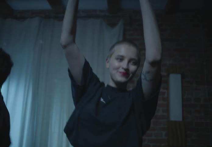 Lights are flashing as a woman dances around a room