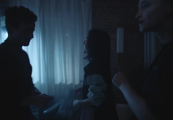 A group of teenagers dance together in a house