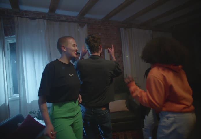 A group of teenagers dance together in a house