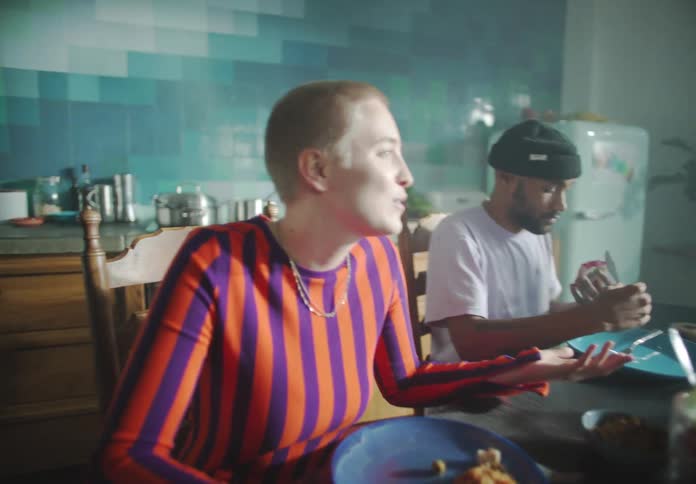 A woman sitting at a dining table talks to the other people around her