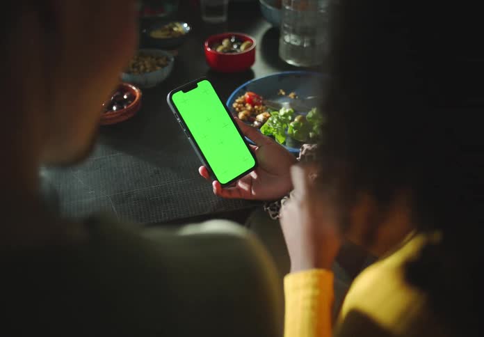 Two people in a restaurant look at a phone together
