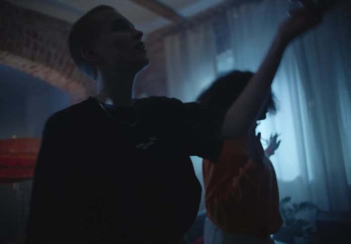 A group of teenagers dance in a house and bat a balloon around in the air
