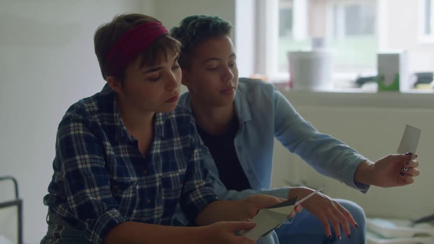 Two women look at paint colors together