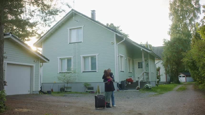 Two women greet outside the house