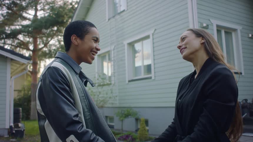 Woman running down porch steps to greet her friend