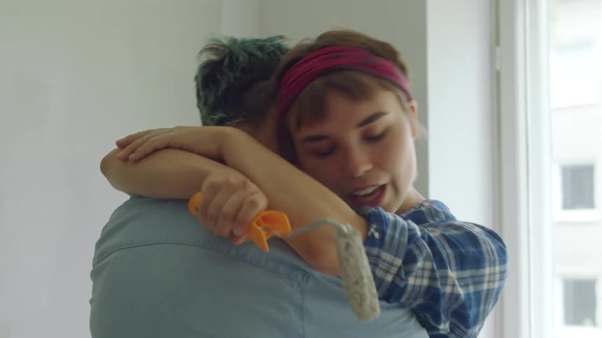 Two women are happy to see each other and hug tightly and dance